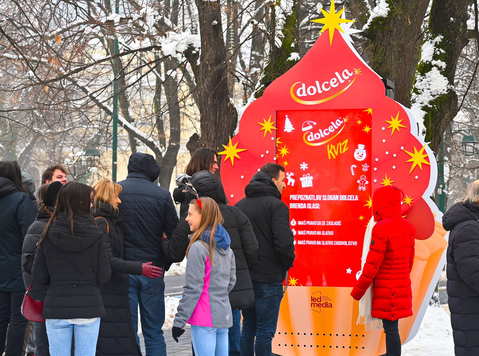 Dolcela kviz štand pod snijegom, okružen posjetiocima